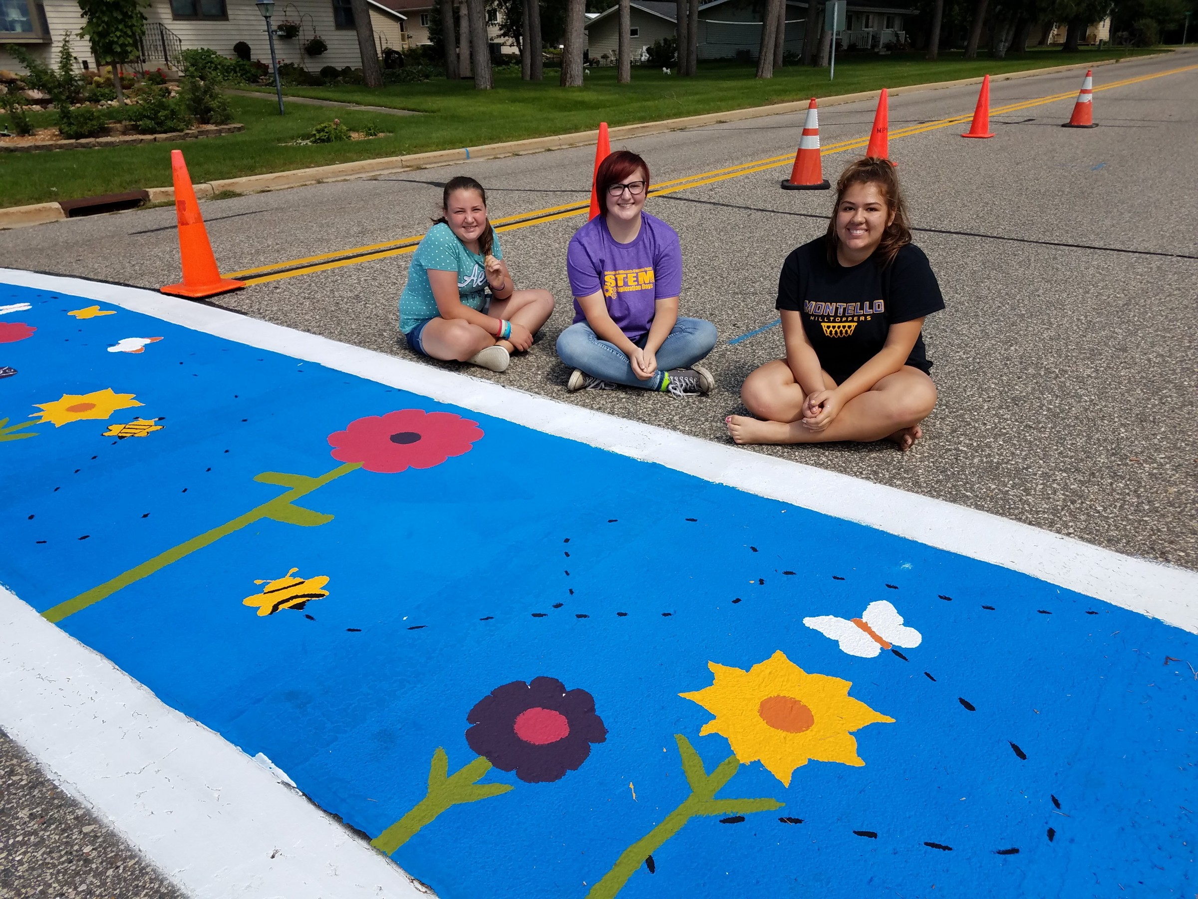 Marquette County youth advocates in front of a crosswalk they painted to promote a sense of community