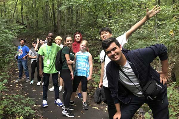 A group of youth enjoying a trip through nature, walking along a trail