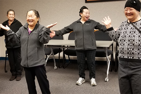 a group of elderly women smiling as they exercise 
