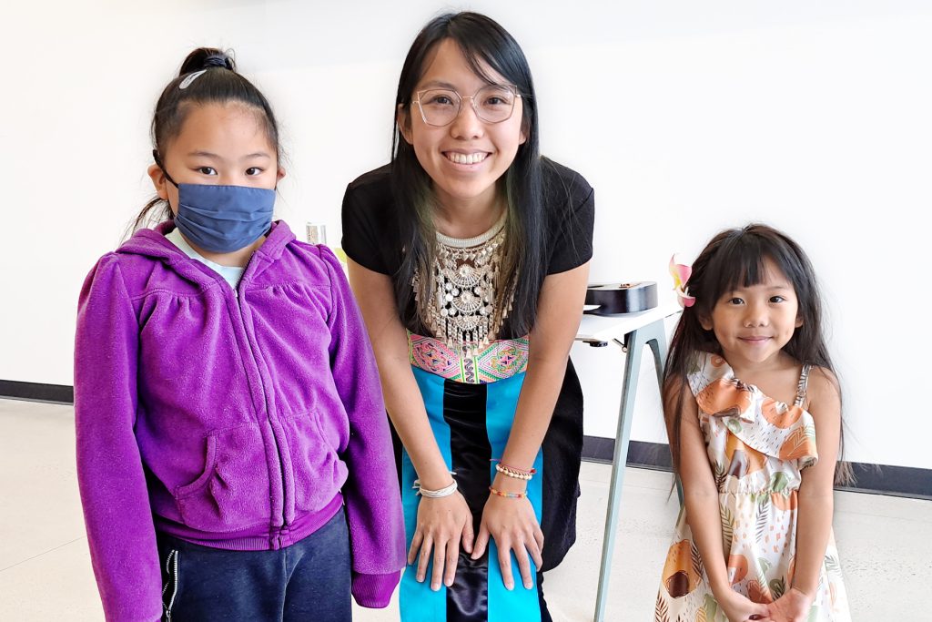 An Extension educator posing with two children.