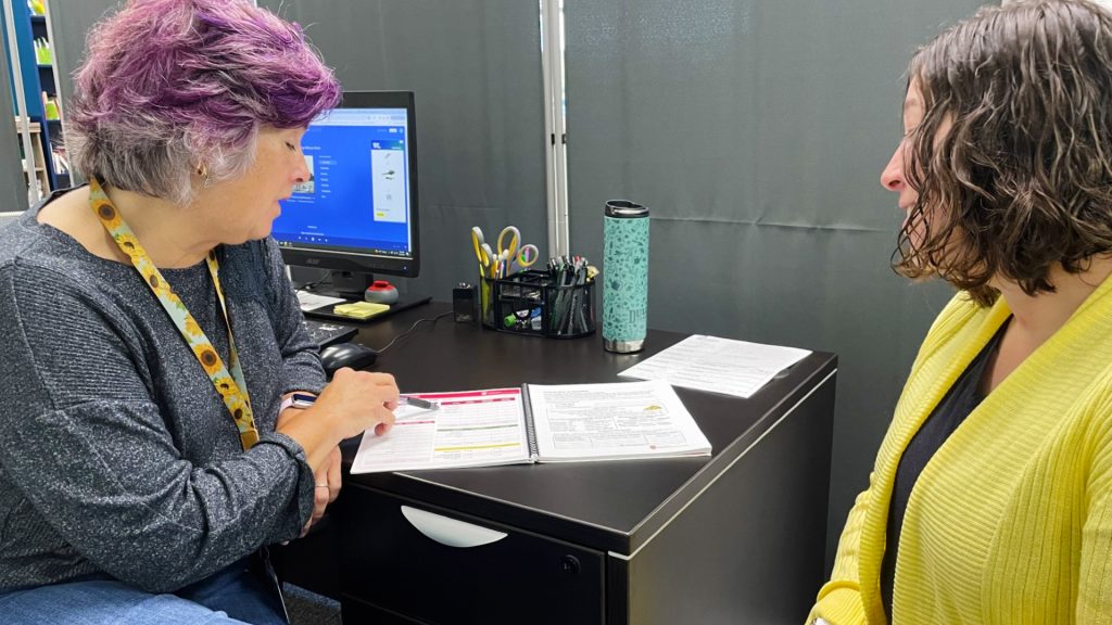 An Extension educator walks a woman through a financial tool she can use.