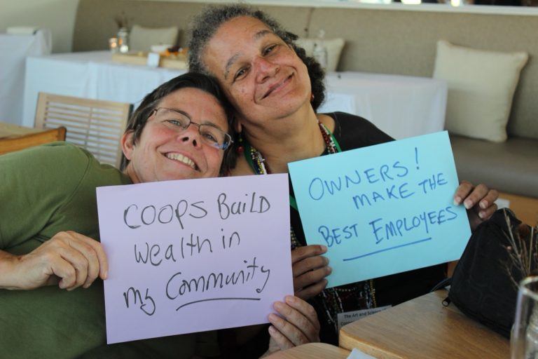 A snow covered tree in a snow covered field in front of a blue sky.