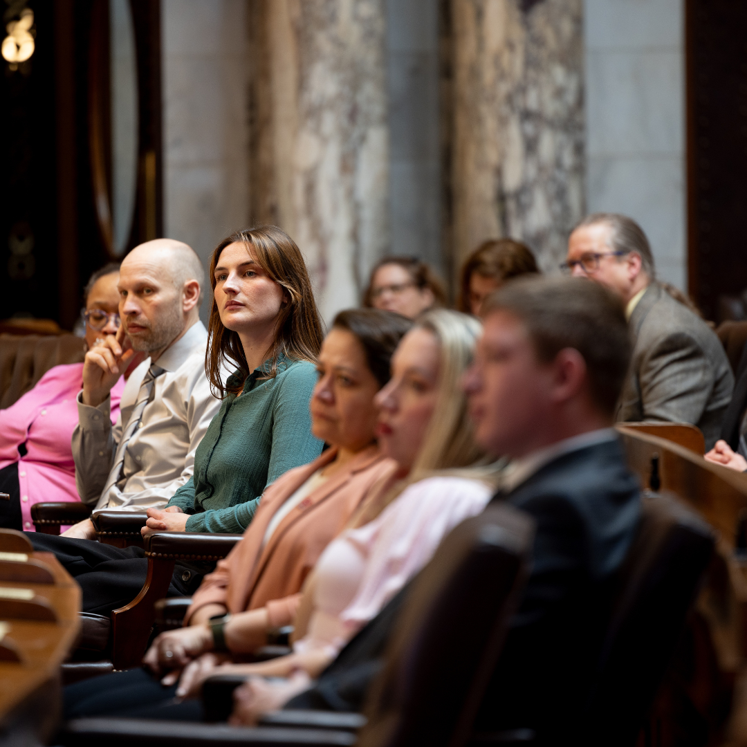 Group of people sitting in an auditorium and listening