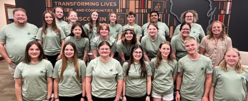 Group of youth and adults in matching t-shirts posing for a photo.